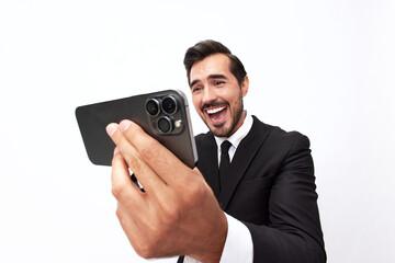 Fototapeta premium Man businessman holding the phone and smiling happily with teeth of surprise. Trading and winning at casinos online via phone. Close-up wide angle photo white isolated background