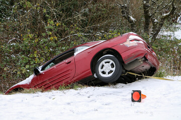 Red sports car crashed into a ditch during a snow storm