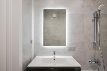 Faucet with ceramic sink and mirror in the bathroom