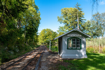 A small building, not much larger than an outhouse, stands beside a train track through a forest near Sparta, Ontario. This claims to be North America's smallest Union Station.