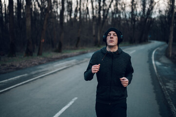 Fototapeta premium Redhead young man running outside on a mountain road