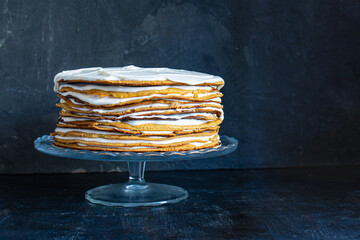 a whole round honey cake on a stand against a dark background - 536442689