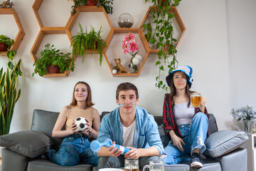 Three young Argentinean friends in concentration, watching their national soccer team's match.