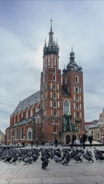 VERTICAL VIDEO - Time Lapse, Tourists Walk Around The Historical Center Of Krakow On A Sunny Day. Church Of St. Mary, Main Market Square, Krakow, Poland