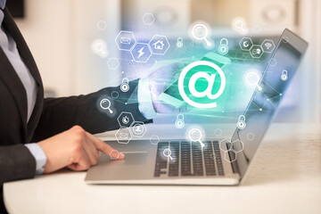 Hands working on laptop with digital icons concept