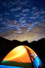 camping tent in a mountain at night , sky with clouds and stars in san miguel de allende guanajuato