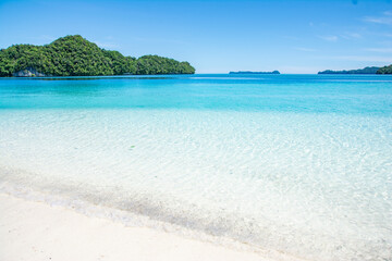 White sand and Blue ocean beach, view of Ulong island from Ngermeaus Island in Rock Islands Souther...