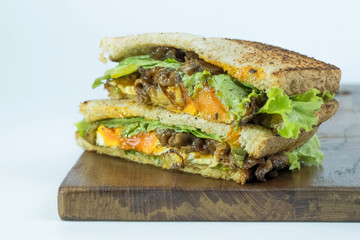 Sandwich on a cutting board. Pieces of appetizing of shortplate beef.
