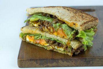 Sandwich on a cutting board. Pieces of appetizing of shortplate beef.