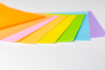 白い机の上に並べられた明るい色の紙