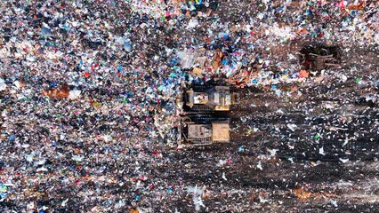 Dozer on Garbage Dump. Landfill with solid household waste, rubbish, waste plastic and polyethylene. Solid waste disposal and landfill gas collection. Ecology and Environmental pollution. - Powered by Adobe