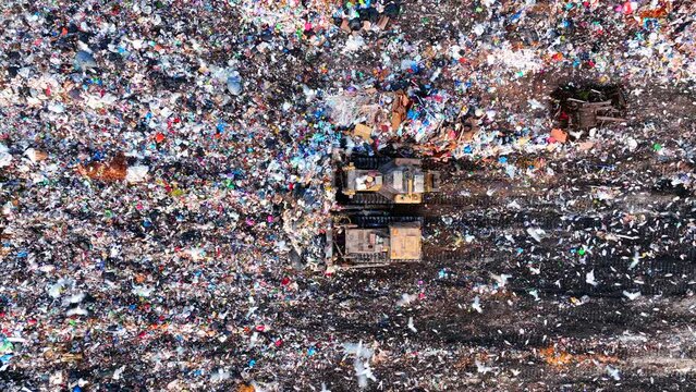 Dozer on Garbage Dump. Landfill with solid household waste, rubbish, waste plastic and polyethylene. Solid waste disposal and landfill gas collection. Ecology and Environmental pollution. 
