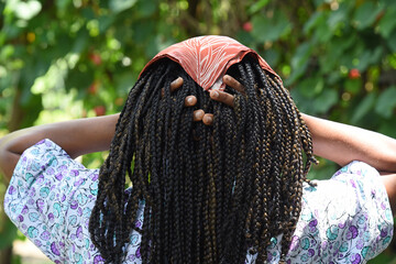 female hairstyle with braids in rows, braided hair, afro. synthetic hair.Woman holding her hair...