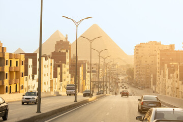 Cairo street with pyramids in the background
