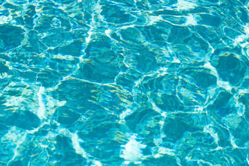 Water background, ripple waves. Blue swiming pool pattern. Sea surface. Water in swimming pool with sun reflection. Banner with copy space.