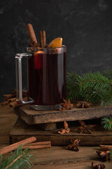 Christmas hot drink. Mulled wine with cinnamon, orange and anise on a wooden background.