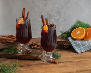 Mulled wine with cinnamon, orange and anise on a wooden background.