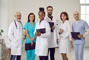Group portrait of diverse multiethnic doctors in medical uniform pose in clinic. Smiling...