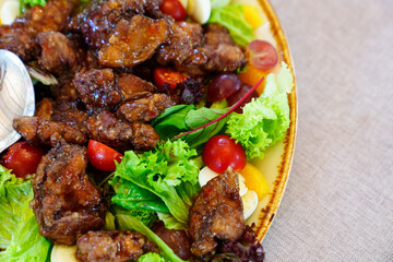 salad with caramelized eggplant, tomatoes, quail eggs and lettuce on a plate.