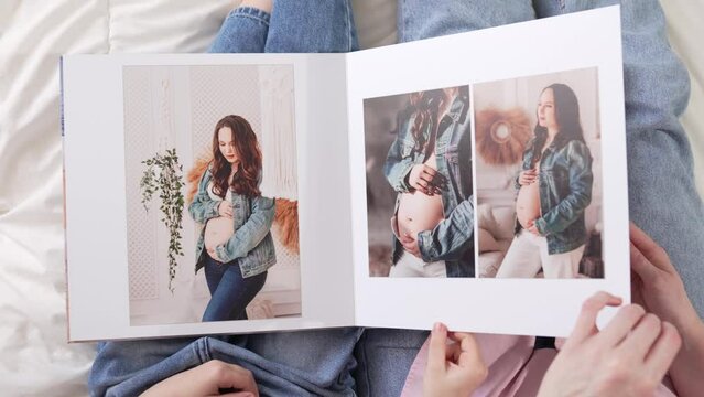 top view. pages of a photobook with photos of a pregnancy family photo shoot
