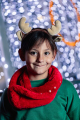 portrait of happy little girl with christmas reindeer antlers