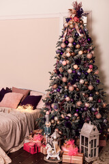 Large Christmas tree in the bedroom by the bed