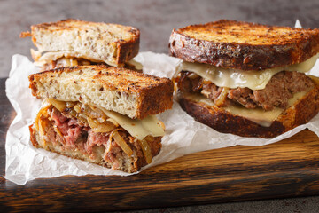 classic beef patty melt sandwich using crispy rye bread, cheese, and tender onions closeup on the...