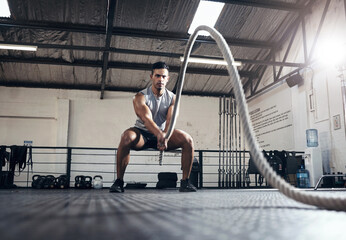 Man, workout and fitness with rope at gym for health, exercise and body wellness. Healthy, muscle...
