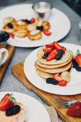Pancakes with honey and berries for breakfast. French breakfast with blueberries and strawberries.