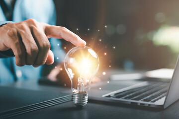 Businessman's hand touching on a light bulb, innovative and inspirational concept,Technology...