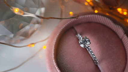Close up of diamond ring with light bokeh background. Love, valentine, relationship and wedding concept. Soft and selective focus.