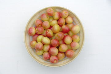 Fresh pink cherries in a plate on a white background.Top view. Close-up.
