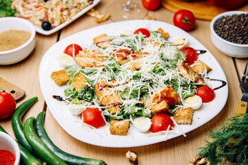 Healthy Caesar salad of chicken with tomatoes and croutons. Restaurant serving dishes on a plate.