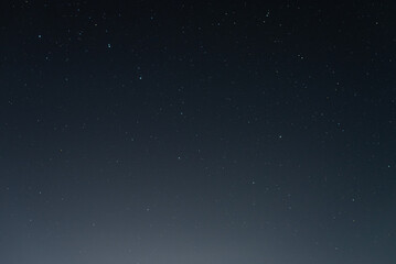 Many stars on black sky at night. A real dark night sky with plenty of stars. Night sky background with selective focus
