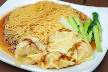 Chinese food : Yellow noodles and pork dumplings