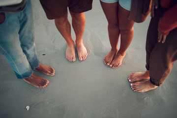 Friends, feet and beach in water, sand and travel summer vacation with diversity, men and women. People group relax on tropical sea holiday with wet toes together while traveling, friendship and trip