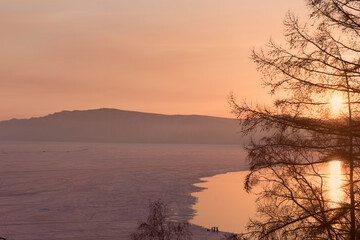 Beautiful sunset on frozen lake Baikal. Winter landscape.