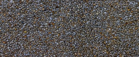 Panorama of small pebbles in concrete wall for background