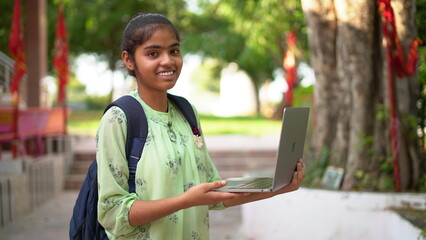 cheerful pretty / beautiful Indian student using laptop while studying and showing her success....