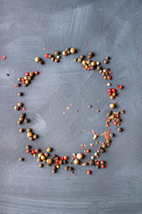 peppercorns are scattered on a black background, copy space