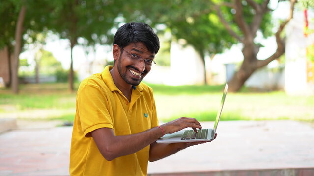 Picture of handsome man in casual t-shirt holding silver notebook and chatting or working.