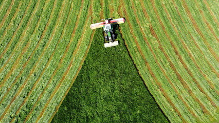 Bauer mäht mit Traktor eine Wiese (Drohnenaufnahme)