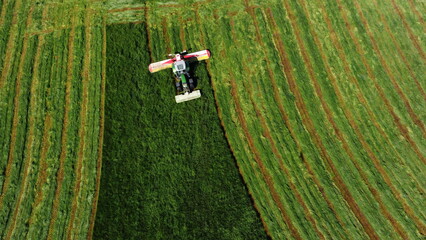 Bauer mäht mit Traktor eine Wiese (Drohnenaufnahme)