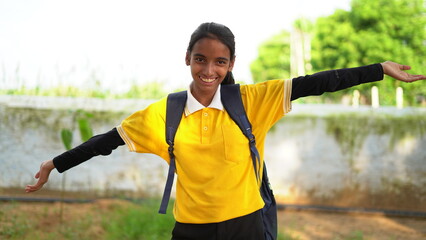 Happy smiling indian schoolgirl in school uniform with backpack bag. Portrait of smart Indian girl kid student.