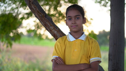 Happy smiling indian schoolgirl in school uniform looking into camera. Portrait of smart Indian...