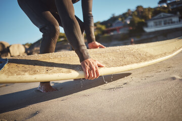 Hands, surfboard and beach surfer man on holiday, vacation or summer trip in Hawaii. Fitness, workout and male pick up board ready for surfing sports, fitness or exercise by sandy seashore outdoors.