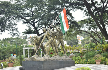 A Picture of Indian Soldiers Planting the National Flag. In Memory of Kargil Divas or Armed forces flag day installed in a park in Bangalore, India