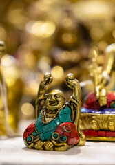 Laughing Buddha idol made of brass with blur background. Selective focus on laughing buddha.