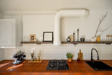 Beautiful stylish kitchen interior with decorated open shelves, black sanitary and tiled table top