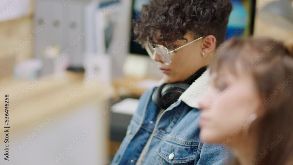 Poster phone, music and thinking with a man and woman design team looking bored in their office at work. co